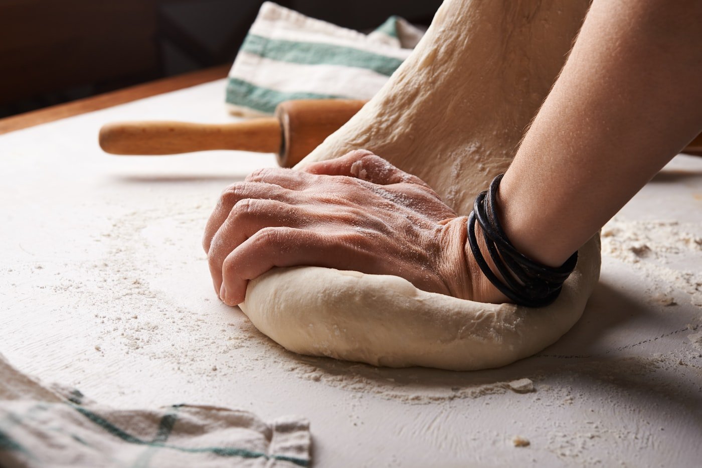 A baker working dough by hand